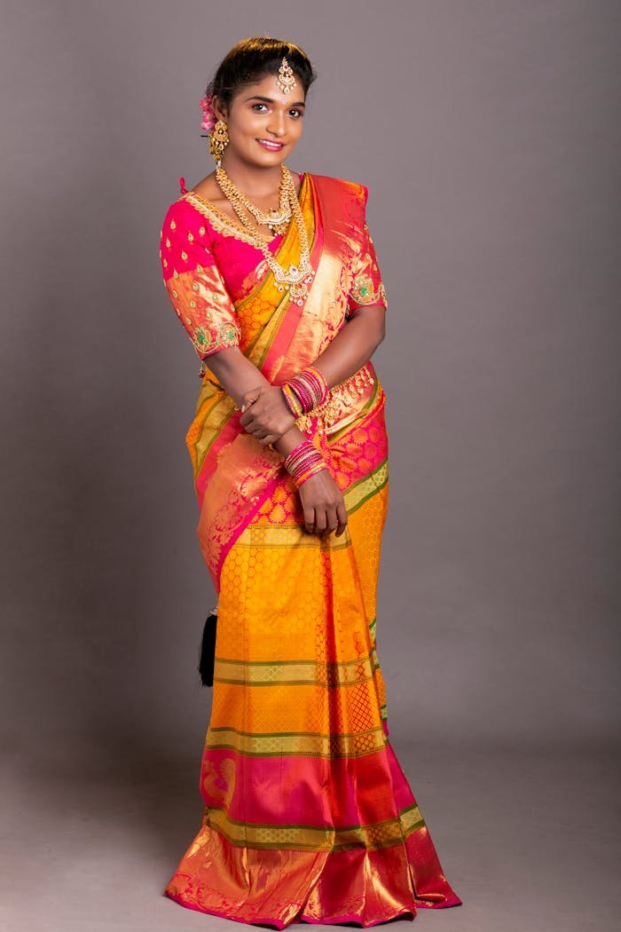Beautiful South Asian woman in traditional saree with vibrant colors and jewelry, studio shot.